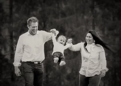 Glückliche Eltern und ihr kleiner Sohn in einer stimmungsvollen Schwarz-Weiß-Aufnahme in der Natur.