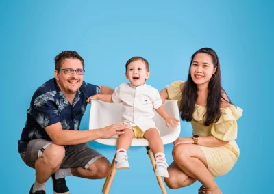 Glückliche Familie im Fotostudio vor hellem blauem Hintergrund