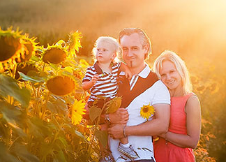 Glückliche Familie im Sonnenuntergang auf einem Sonnenblumenfeld